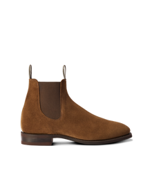 A handcrafted brown suede chelsea boot with a classic chisel square toe, elastic side panels, and a flat heel.